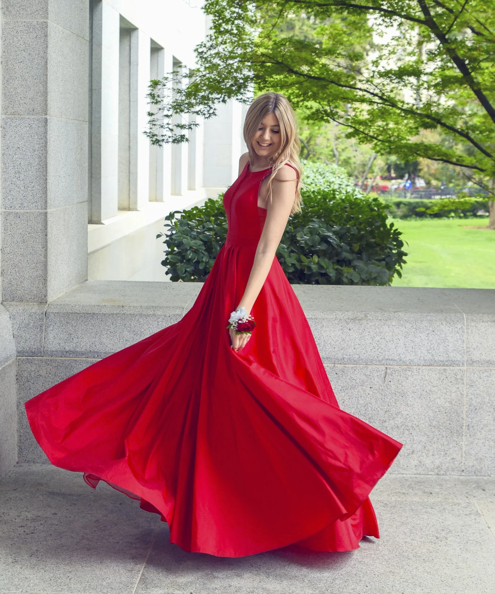 Woman wearing a flowing red dress outdoors.