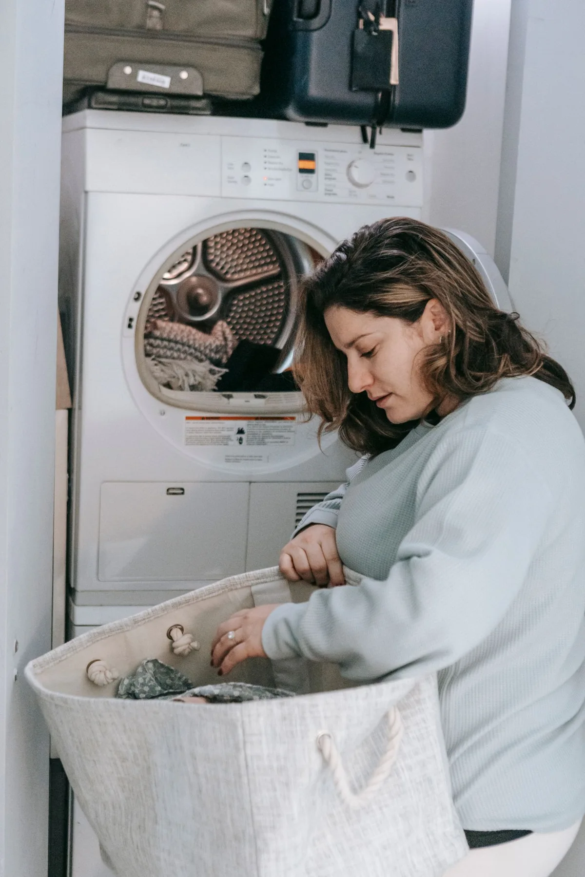 A woman loading clothing into a washing machine