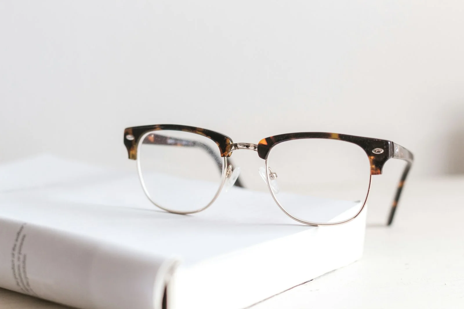 Clear-lens glasses resting on an open book.