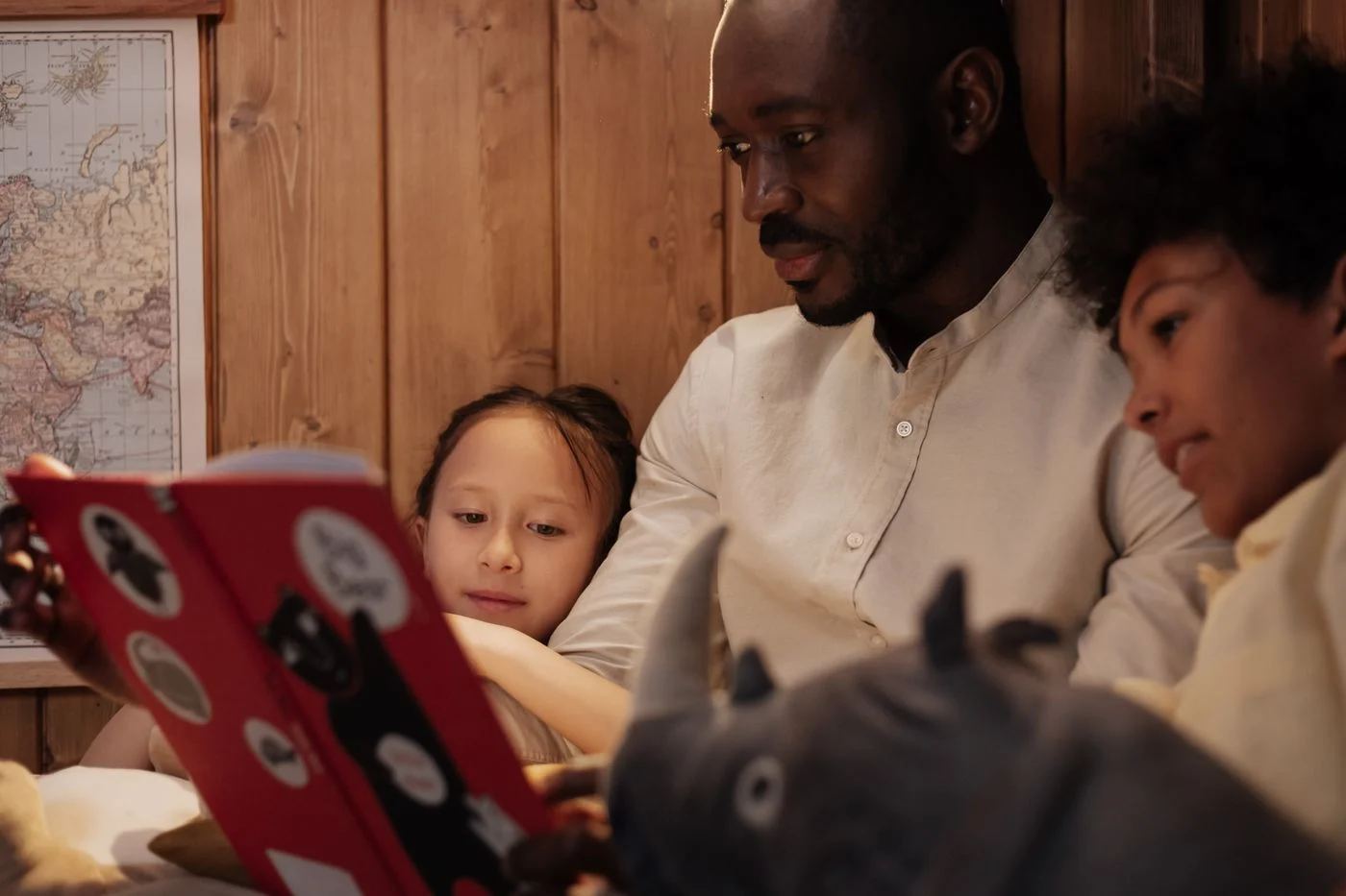 Father and children reading a storybook together at home