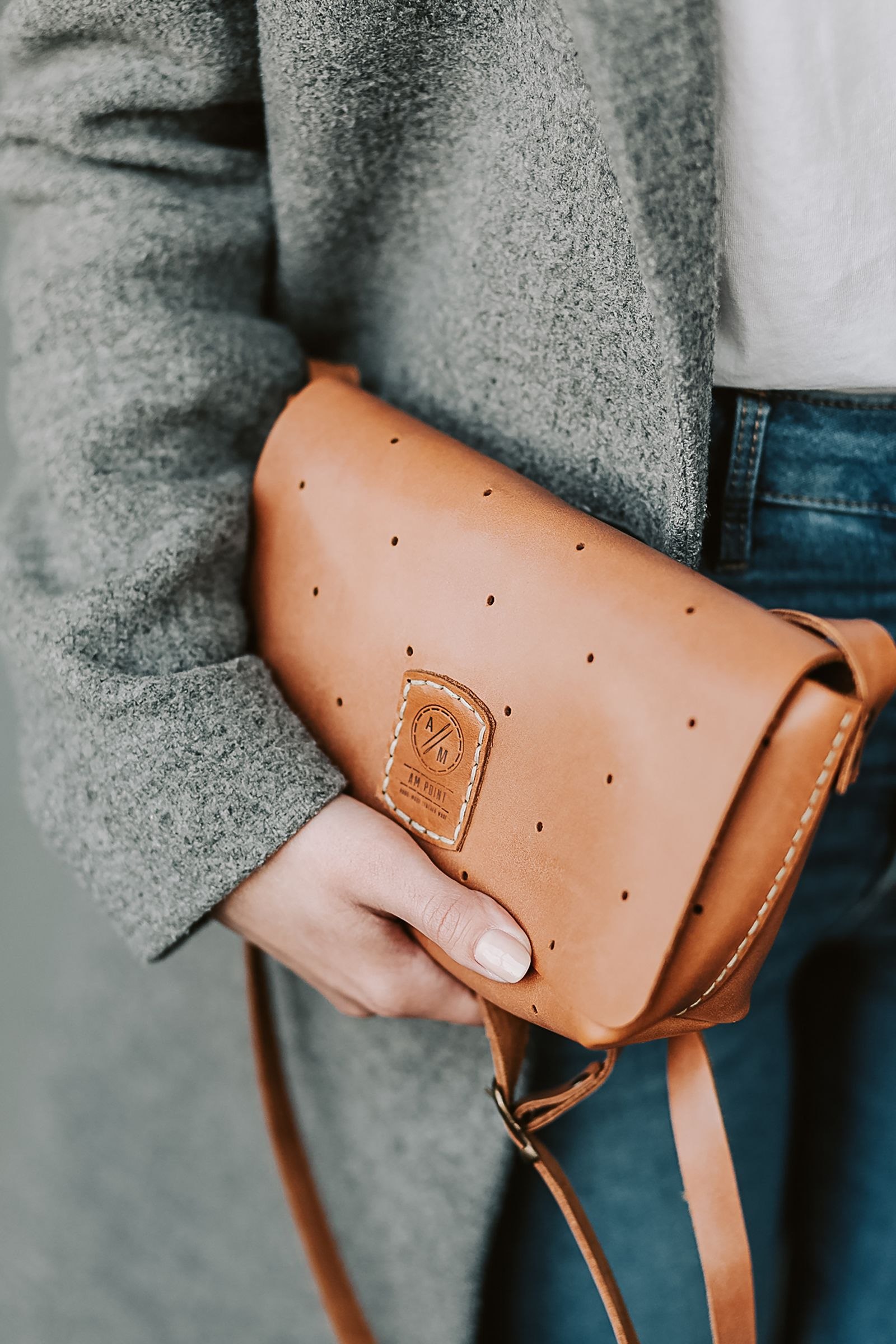 A close view of a tan bag against grey fabric