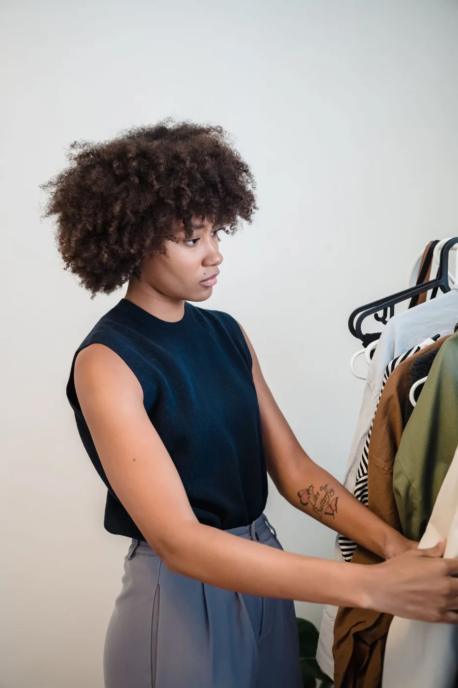 Woman considering clothes hanging on a wardrobe rail