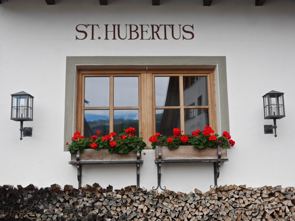 view of the outside of the st Hubertus with red flowers on the window sills