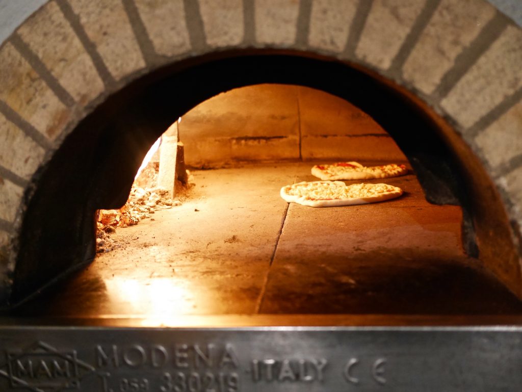 view inside the pizza oven of the two pizzas