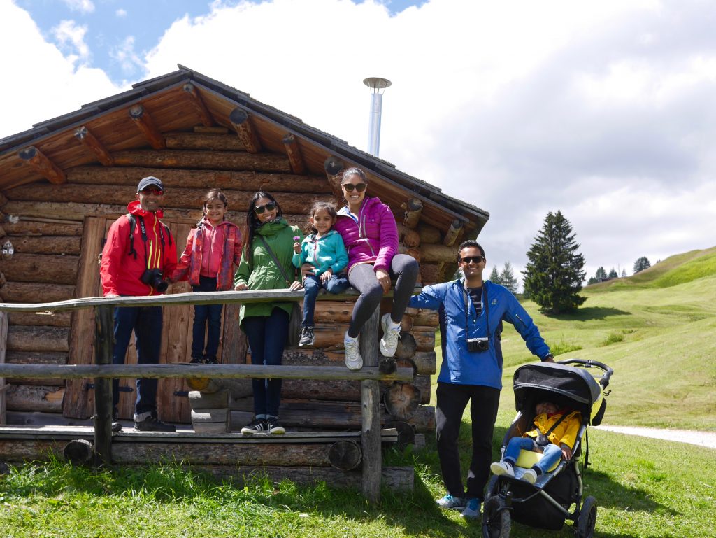 pictures of sima and her family/friends outside a wooden hut