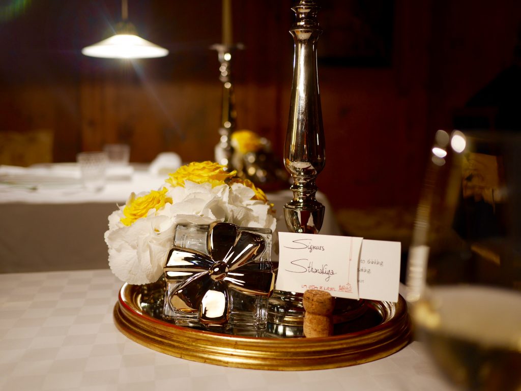 center piece on the table with flowers, silver decor and cork with our family name welcoming us to the restaurant