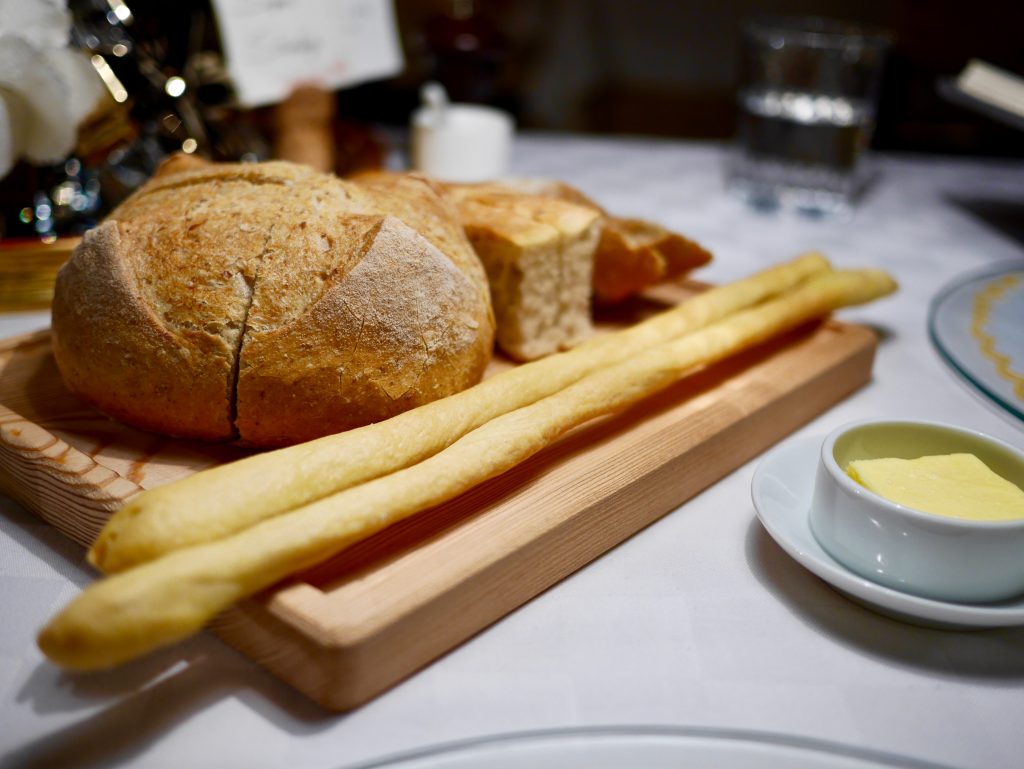 mix of bread on a wooden board alongside butter