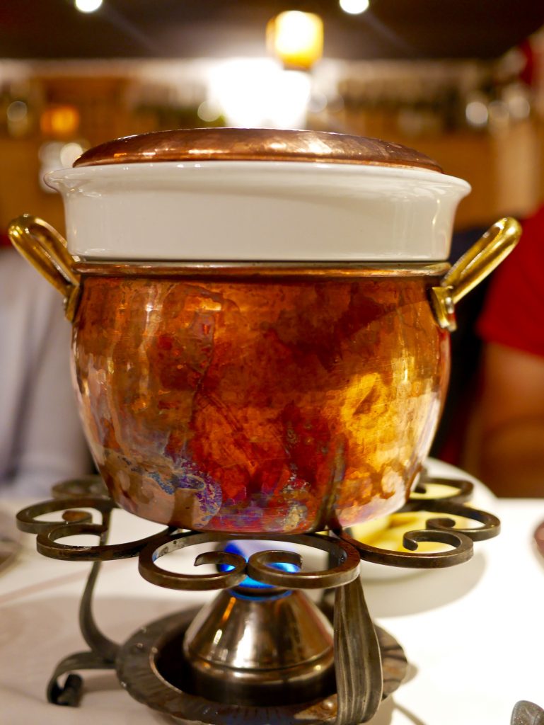 view of the jar holding fondue over flame on a table