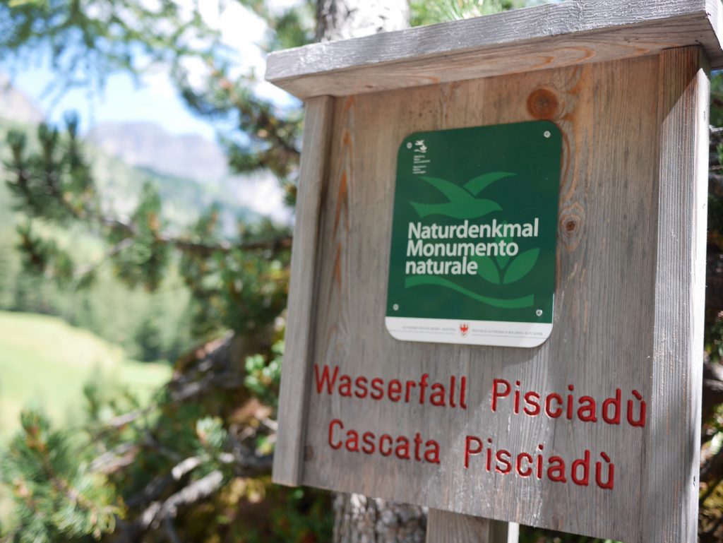 wooden sign at the bottom of the water fall 'wasserfall pisciadu cassata pisciadue'