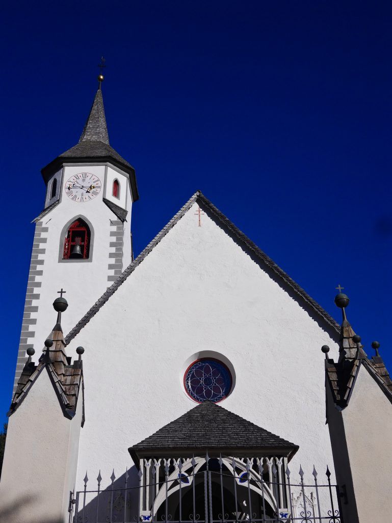 which church with tall spire against dark blue sky