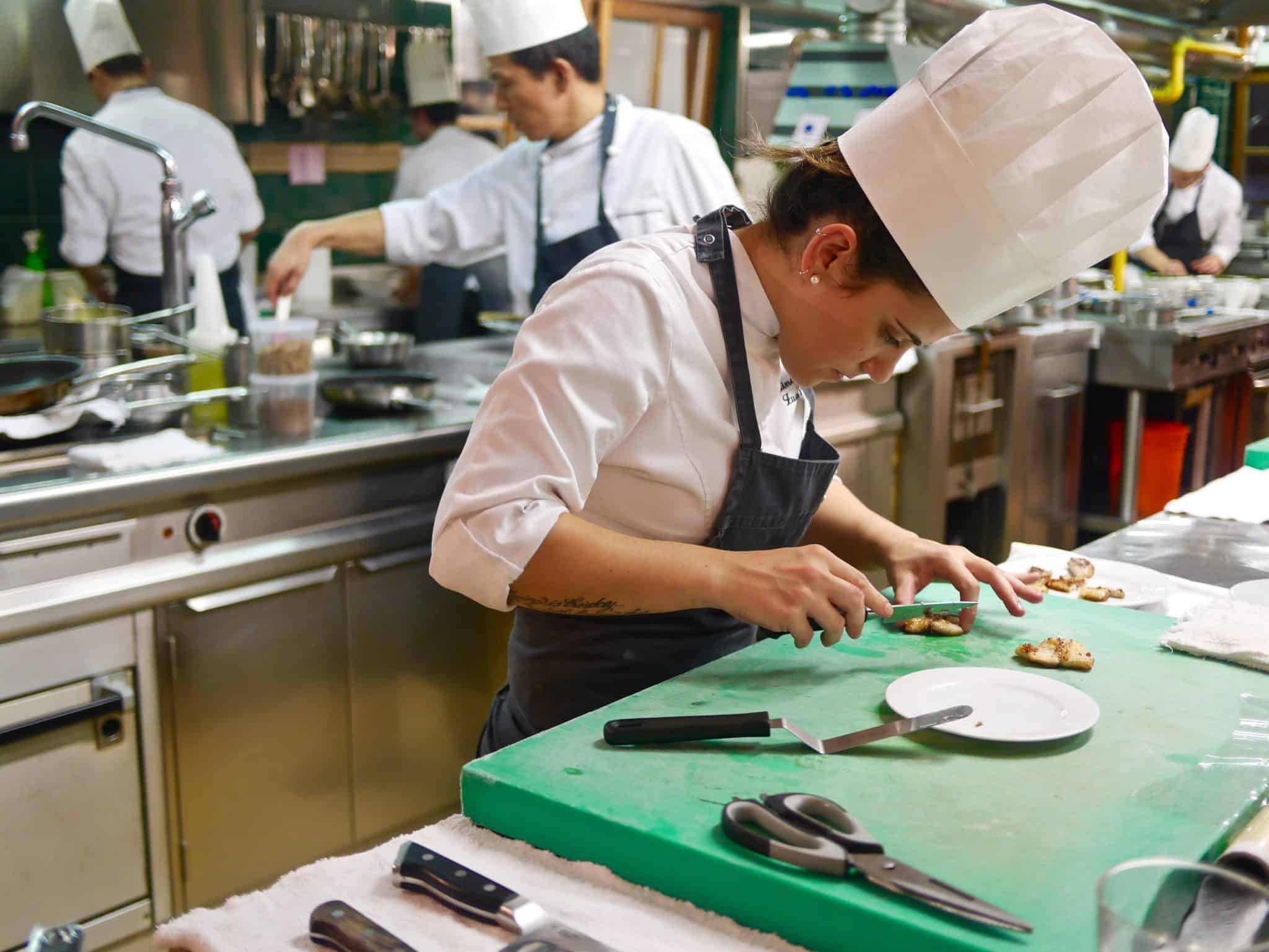 view of chef cutting food on a green chopping board