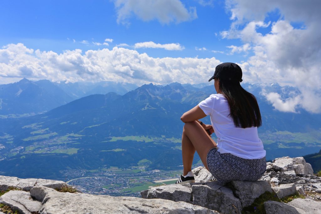 sima sat on a rock overlooking Innsbruck and blue skies