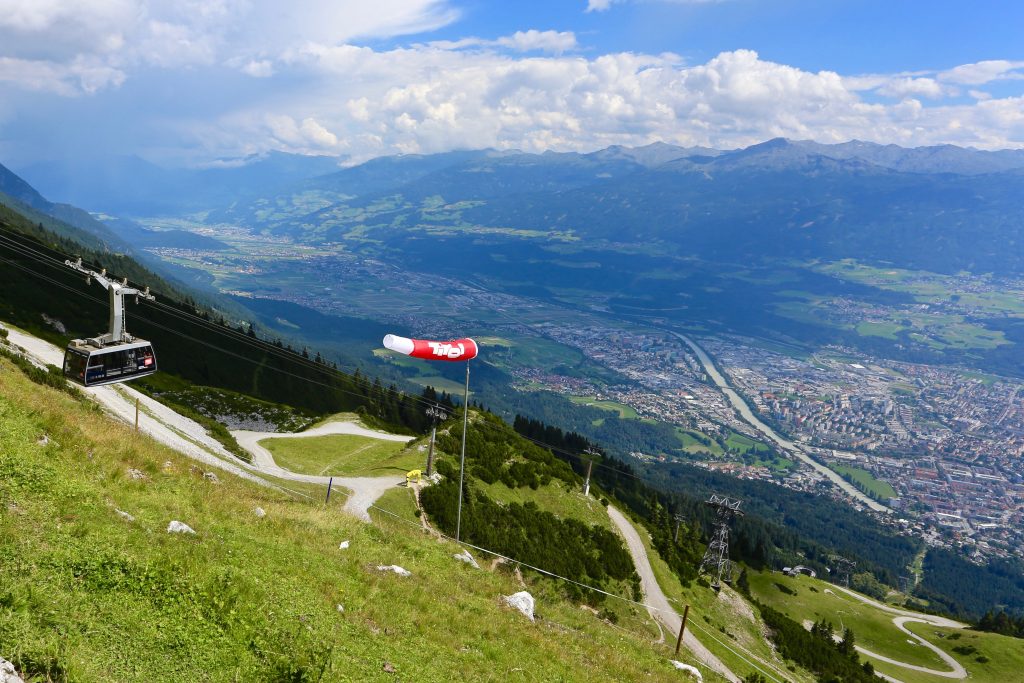 looking down from the mountains towards a cable car and a birds eye view of Innsbruck 