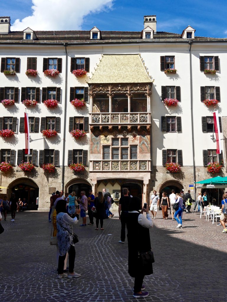 picture of the Goldenes Dachl (Golden Roof) building in innsbruck with red flowers under the windows