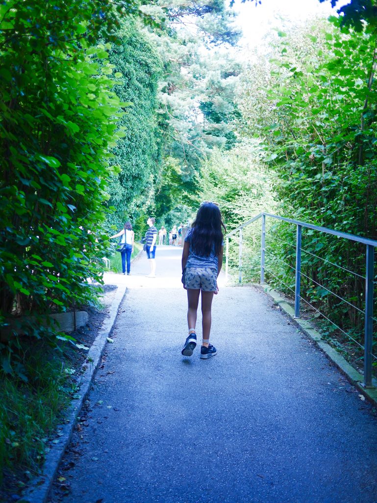 girl walking down a path surrounded by greenery in the Alpenzoo