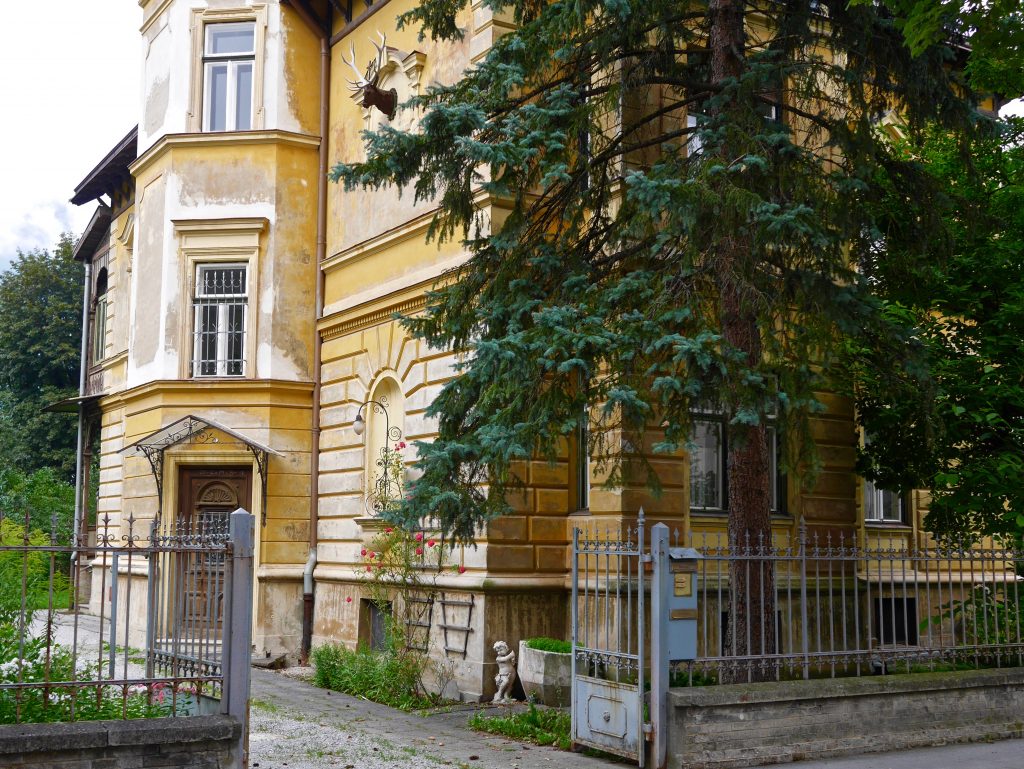 view of a home in Innsbruck painted yellow and surrounded by metal railings