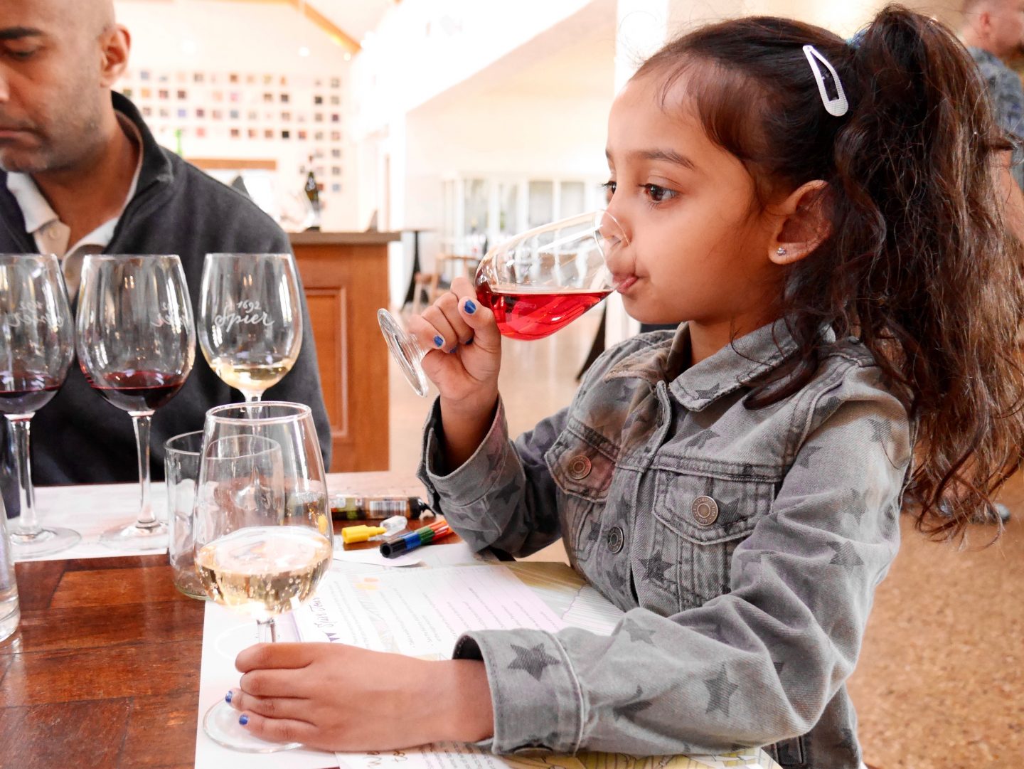girl drinking non alcoholic grape juice in a wine glass in the Cape Winelands