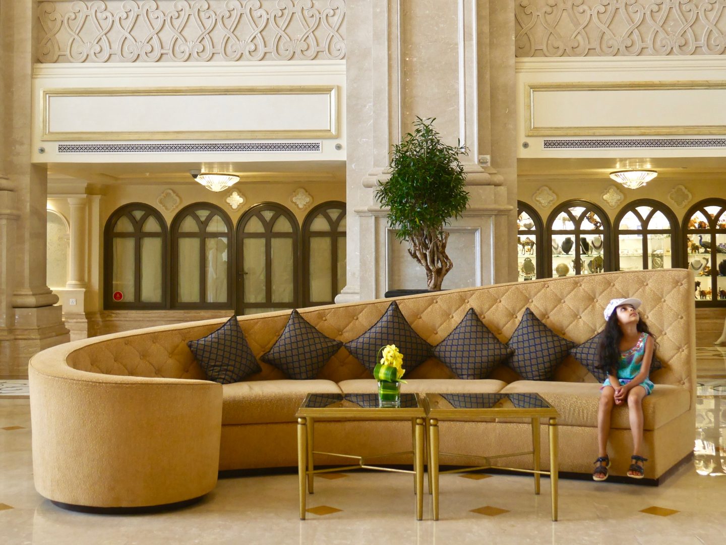 Girl sat on large curled sofa inside of Ritz-Carlton Abu Dhabi Grand Canal