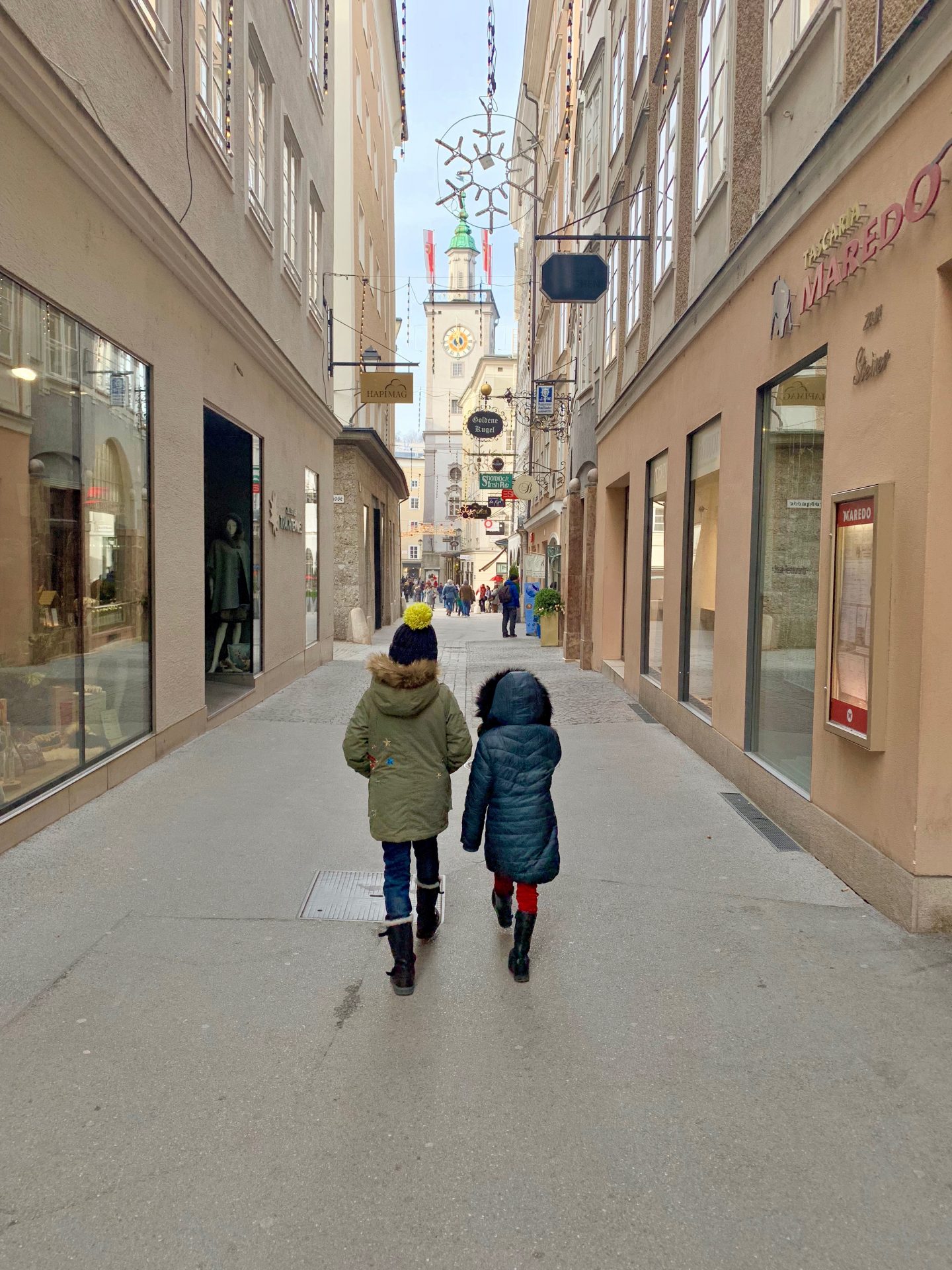two children walking down the streets in the middle of Salzburg