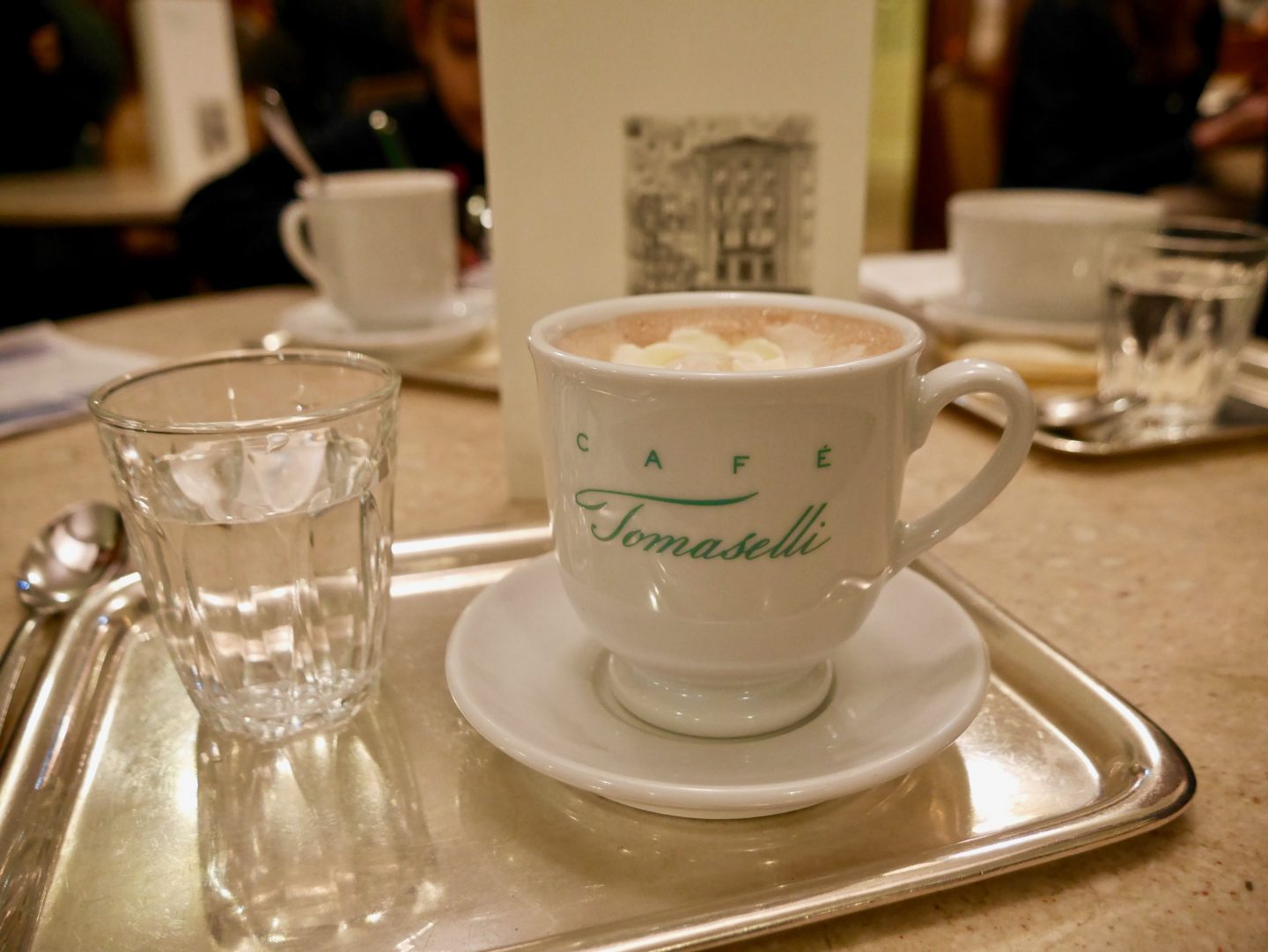 hot chocolate in a white mug on a table in cafe tomaselli