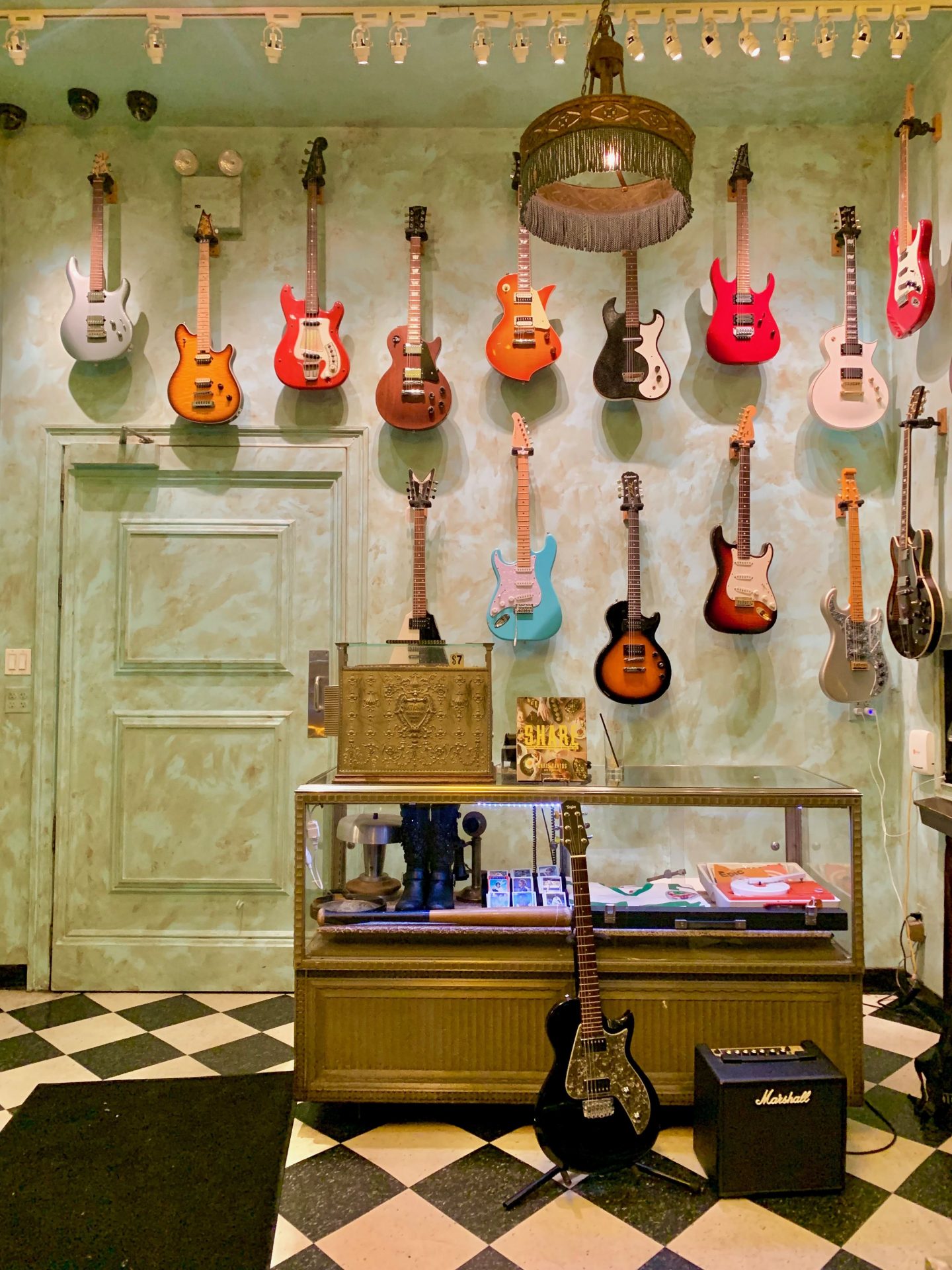 Wall of multi coloured hanging guitars