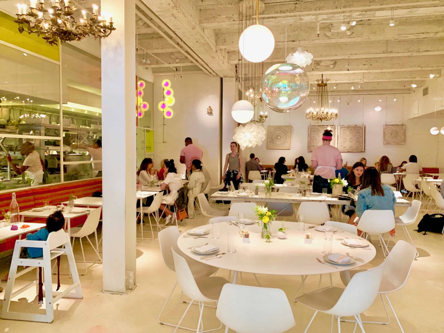 inside abcV restaurant with white floor, white tables and white chairs.