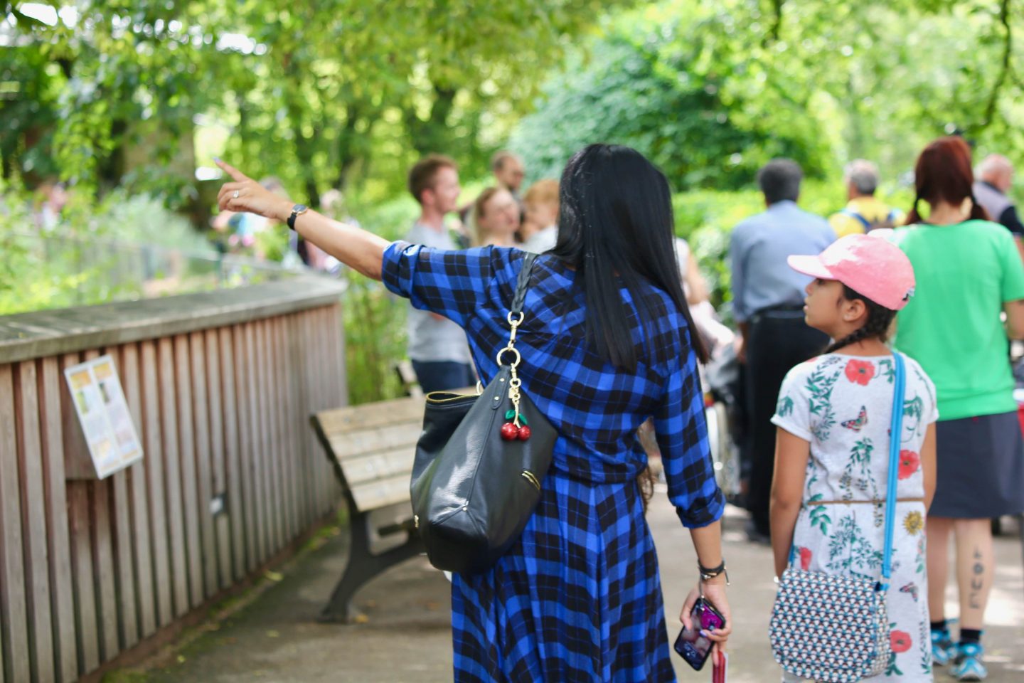 women facing away from shot pointing at attraction within Nuremberg Zoo and visiting germany with kids