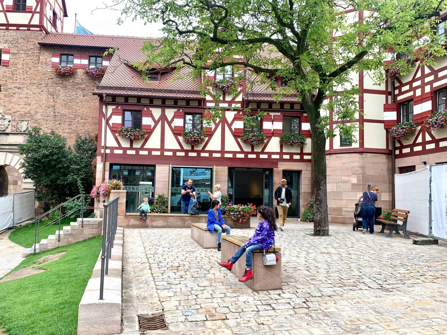 small half-timbered house in the centre of A courtyard with children on benches | Germany with kids
