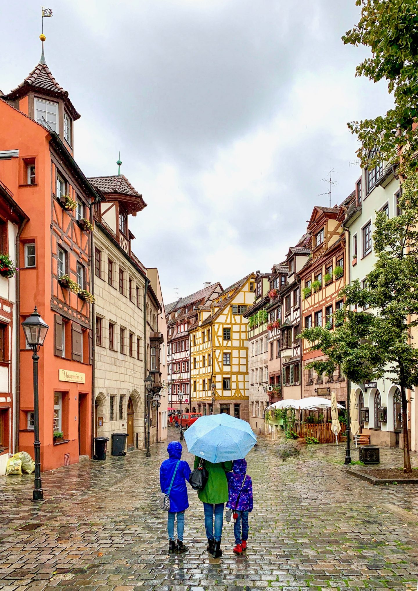 view of Weißgerbergasse (Tanner's Lane) with family facing away under umbrella | Germany with kids