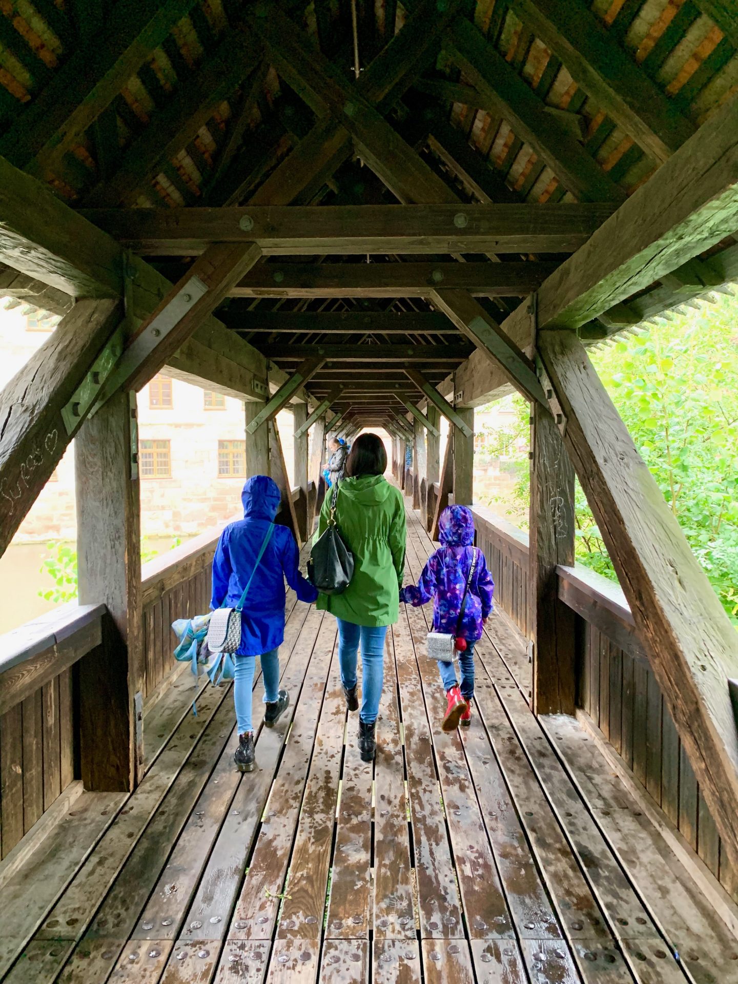 mother and daughters walking away along the wooden Henkersteg  (Hangman's Bridge) | Germany with kids