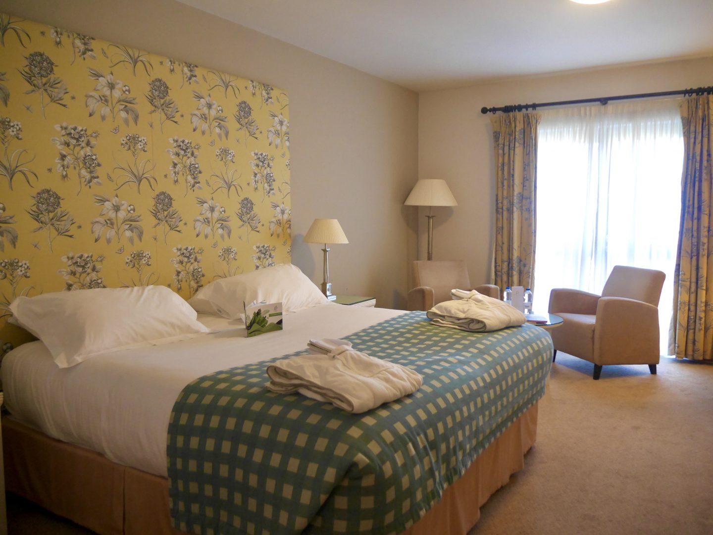 view inside the room with soft furnishing, brown chair, yellow curtains and green and check throw