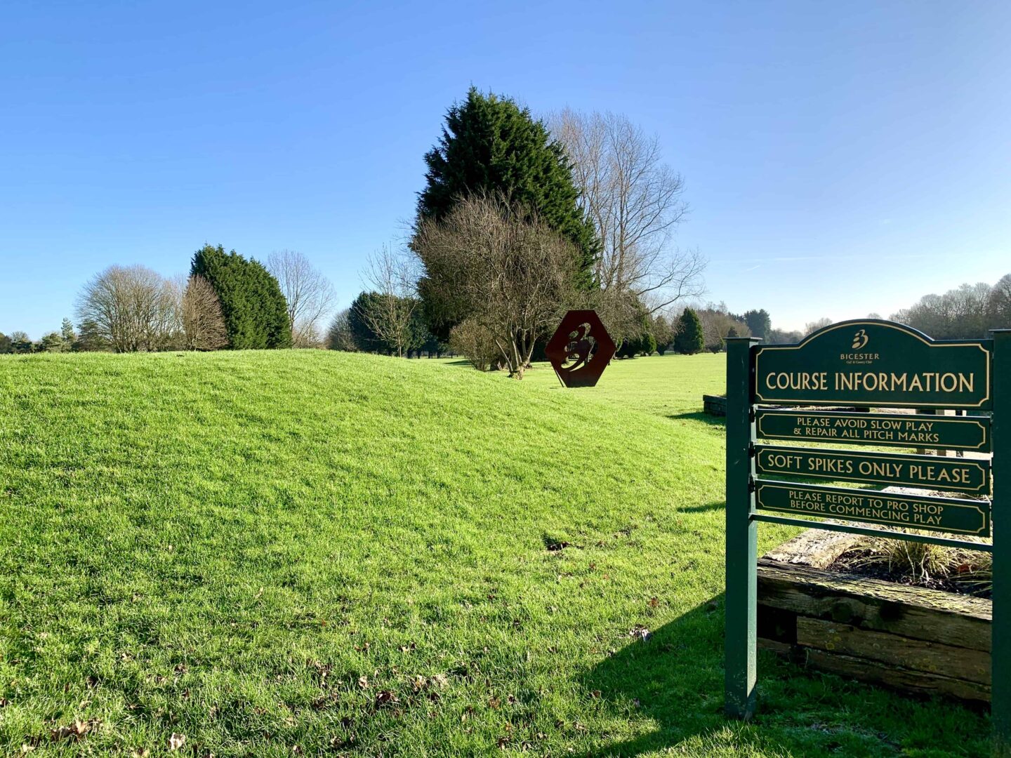 view of a course information sign looking at the fairway of the golf course