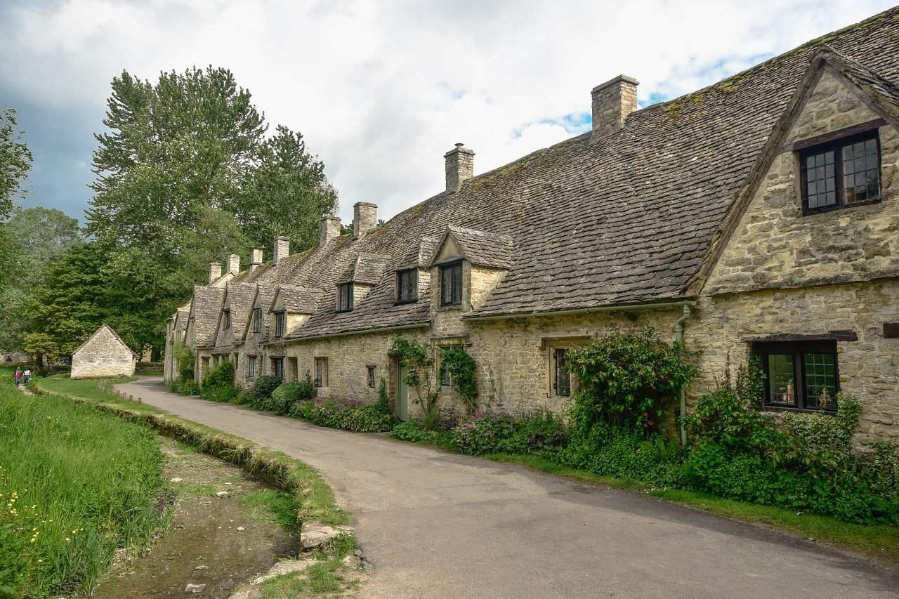 picture of brick built sand coloured cottages on a lane in The Cotswolds