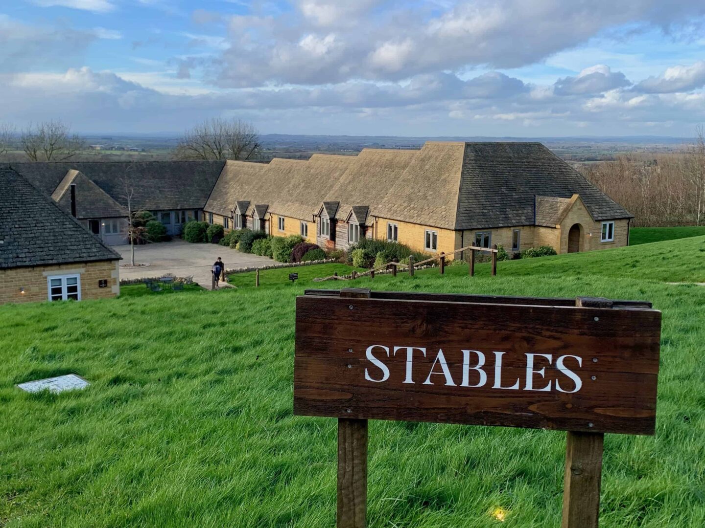 image of the sign 'stables' looking down a hill to the cottages at the fish hotel