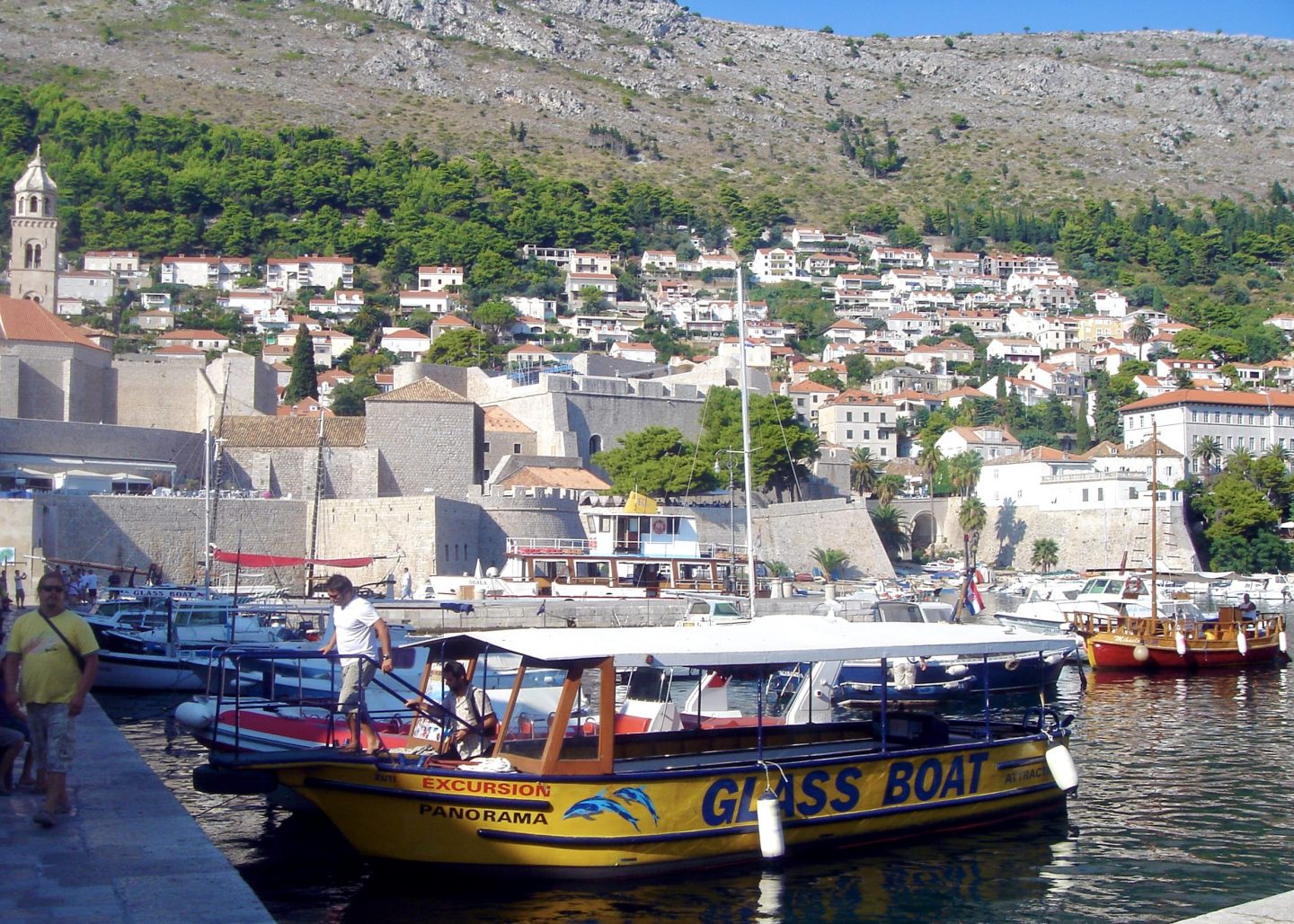 view of the marina in Dubrovnik looking up to the mountains and the white houses on the mountain side