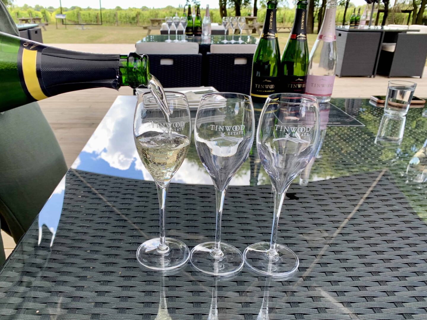 view of three engraves glasses on a table with wine being poured into