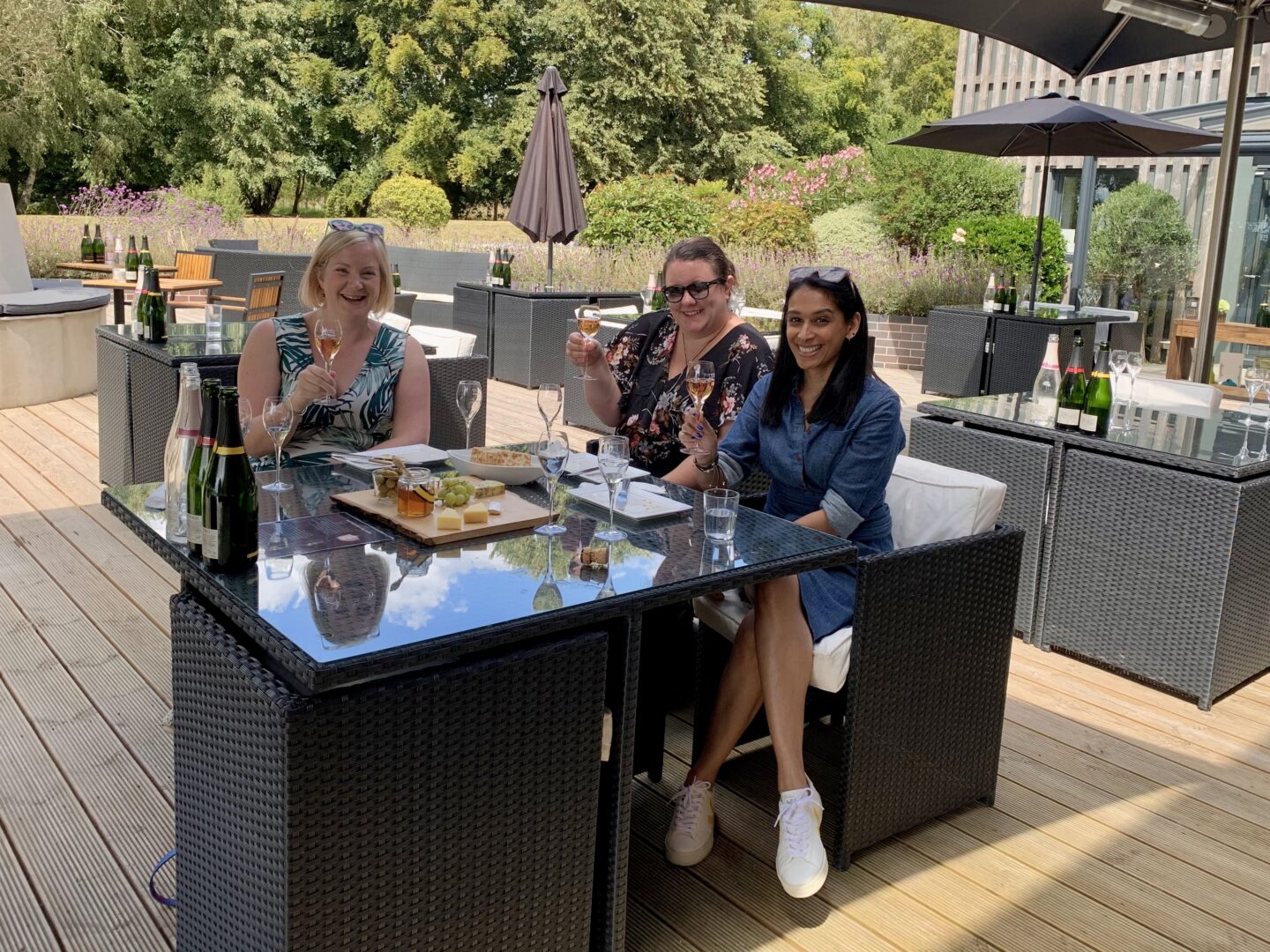view of sima and two friends holding a wine glass at West Sussex vineyard at Tinwood Estate