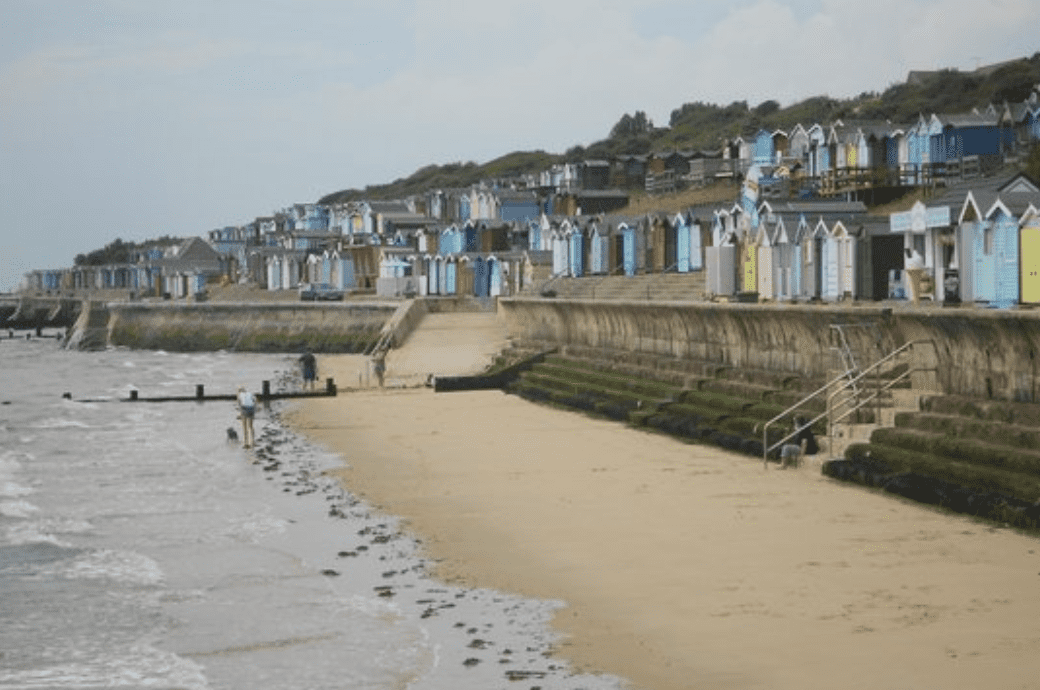 view of the multi coloured beach huts on the shore of the North Sea at Walton-On-The-Naze 