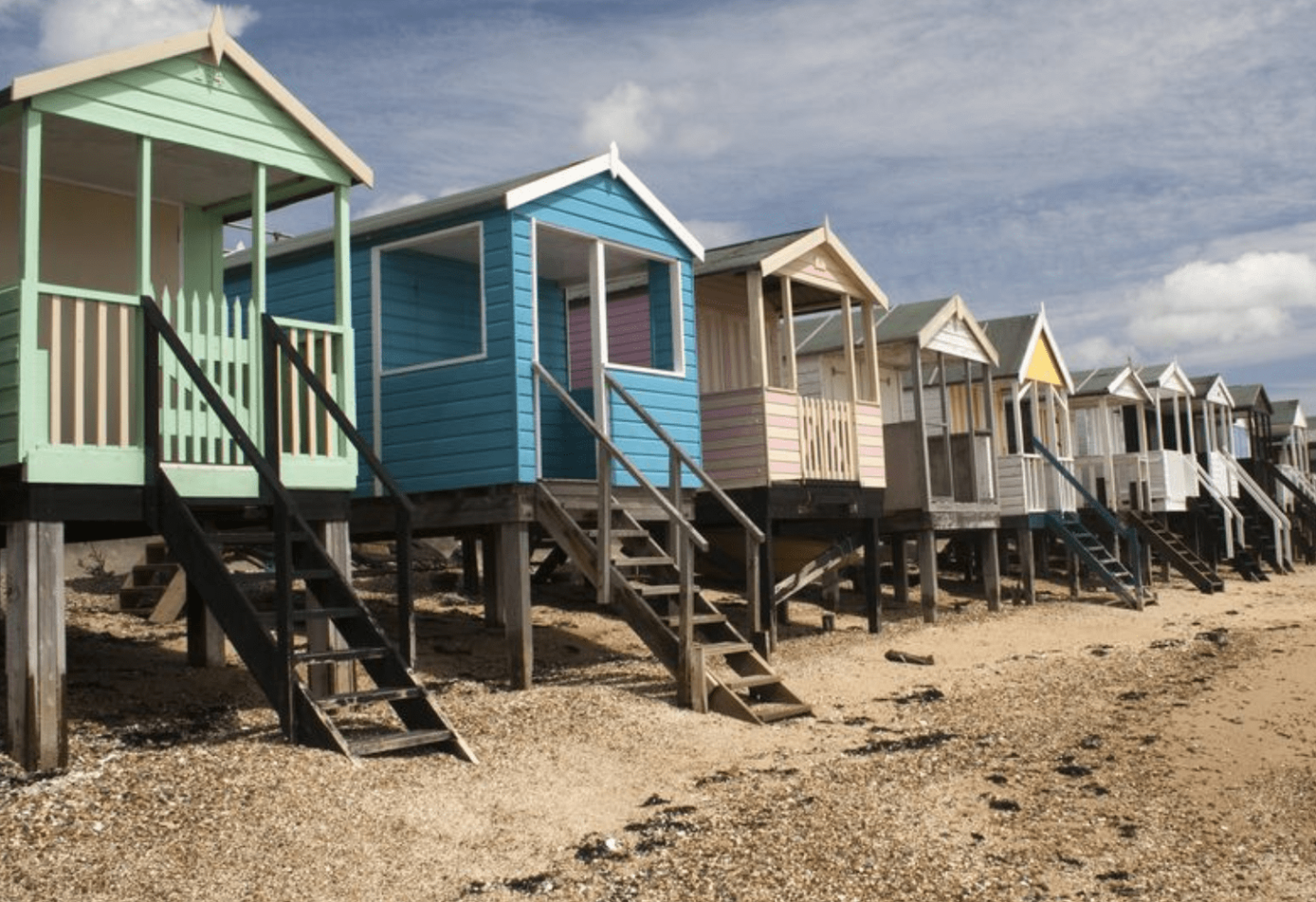 view of the multicoloured beach huts with ladders going to them on the pebbles of Southend on Sea
