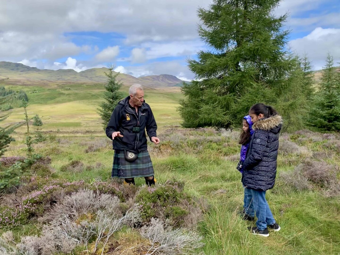 girls listening to the kilt wearing guide in the highlands