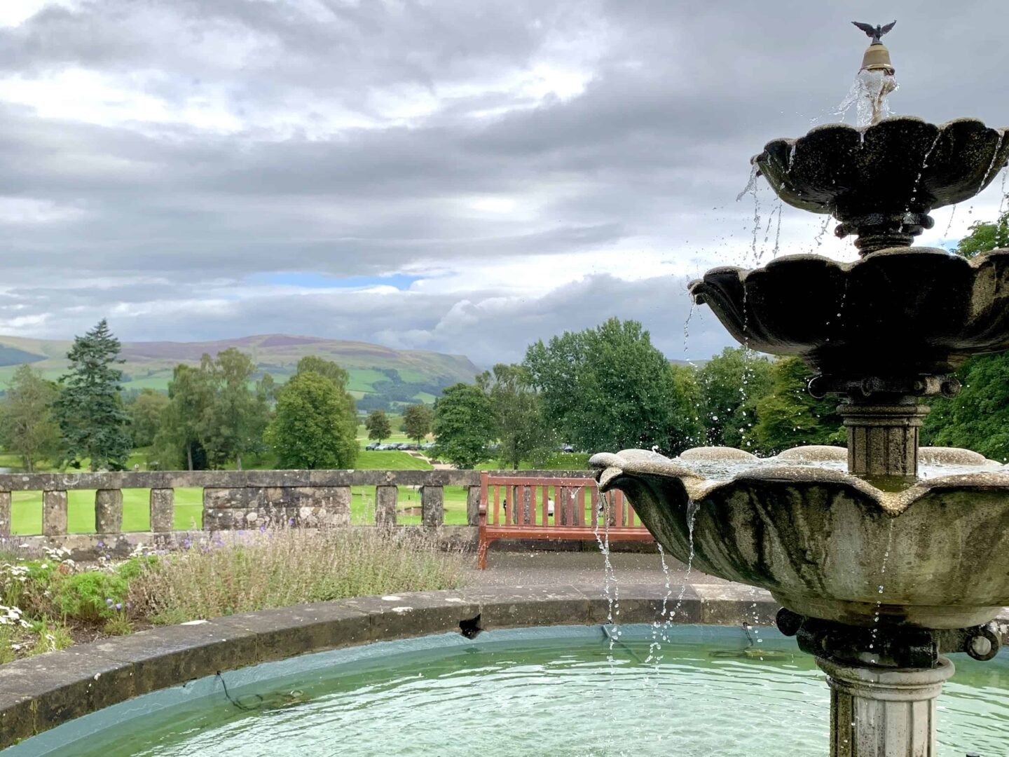 view looking over the hills with the water feature in the foreground and bench overlooking the landscape