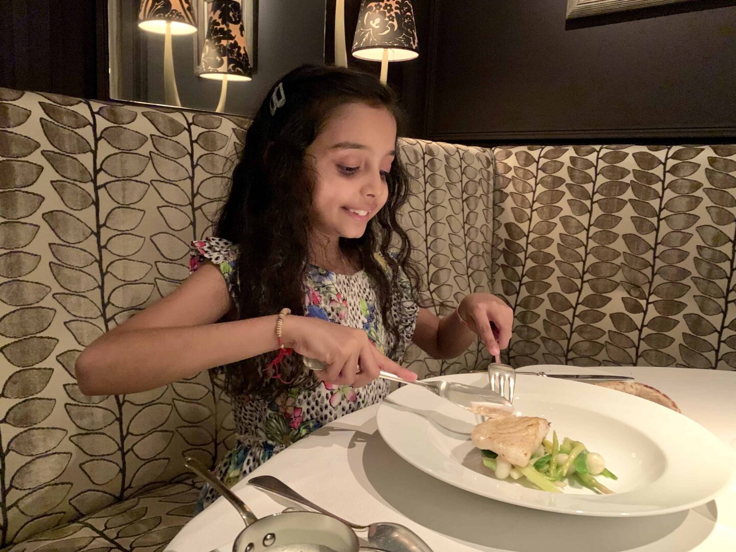sima's daughter eating children's meal on a gold seated corner chair 