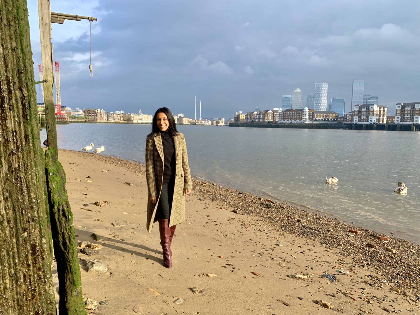 view of sima on the beach looking over to Canary Wharf across the thames