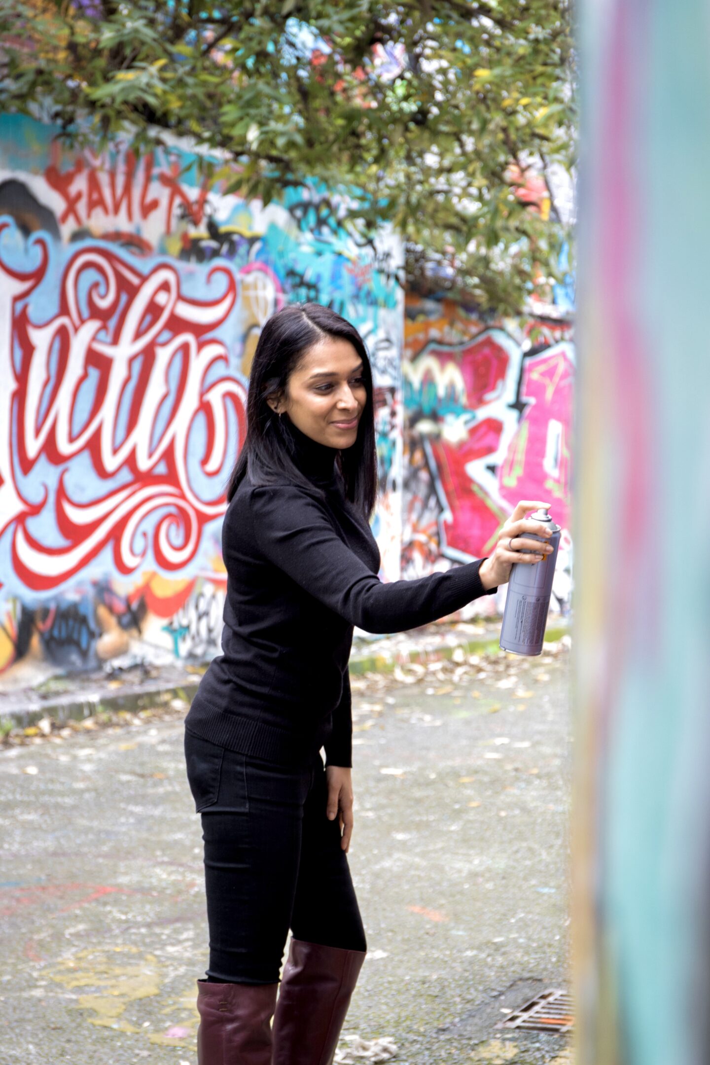 sima holding a spray can towards a wall at Leake street tunnel