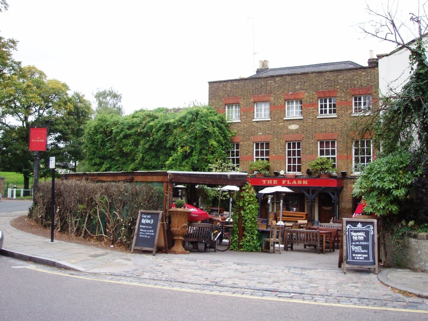 view from the road of the brick and white sash windows with a red sign 'the flask'