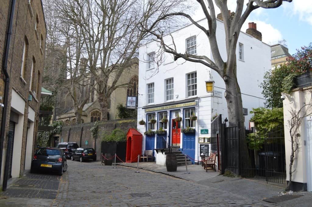 view down the street that houses the white fronted, sash windows, blue & red doors of the grenadier pub